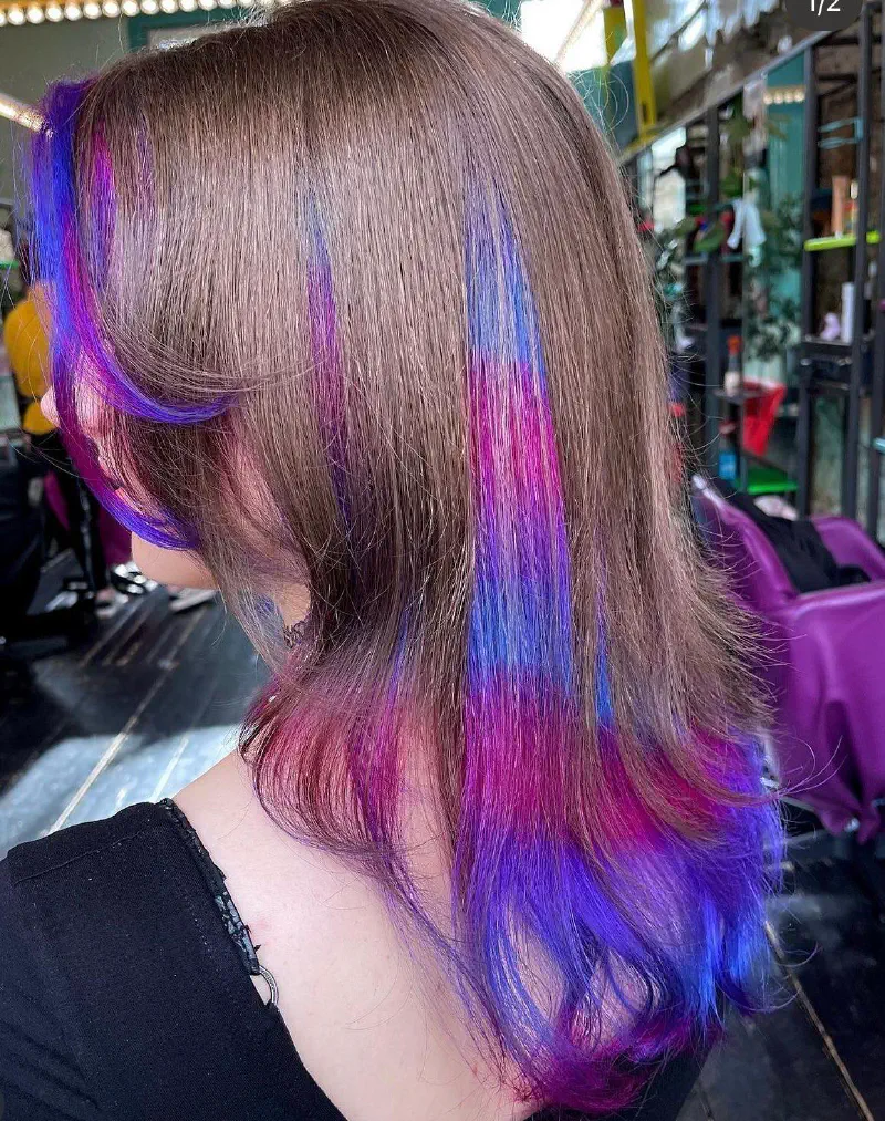 Een persoon met heel erg creatieve kleuren in hun haar